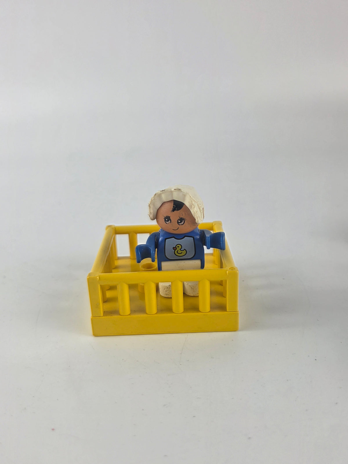 LEGO DUPLO baby figure inside a yellow playpen/crib