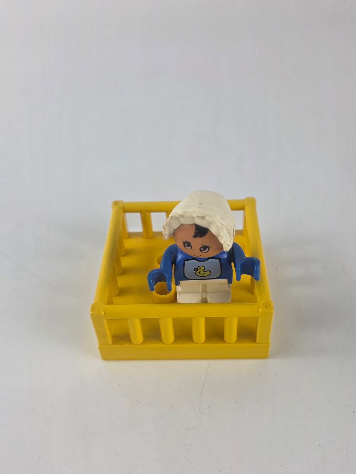 LEGO DUPLO baby figure inside a yellow playpen/crib