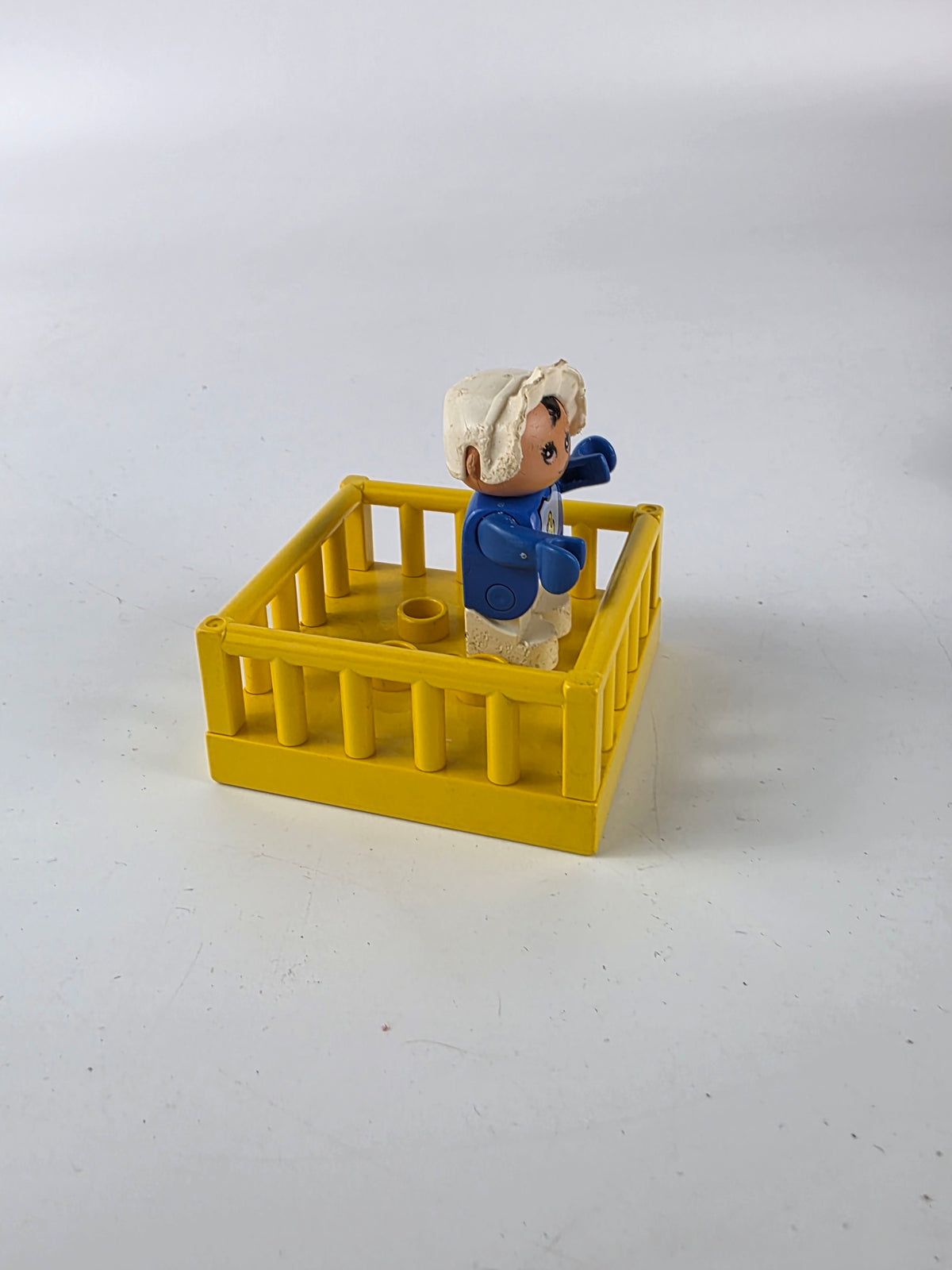 LEGO DUPLO baby figure inside a yellow playpen/crib