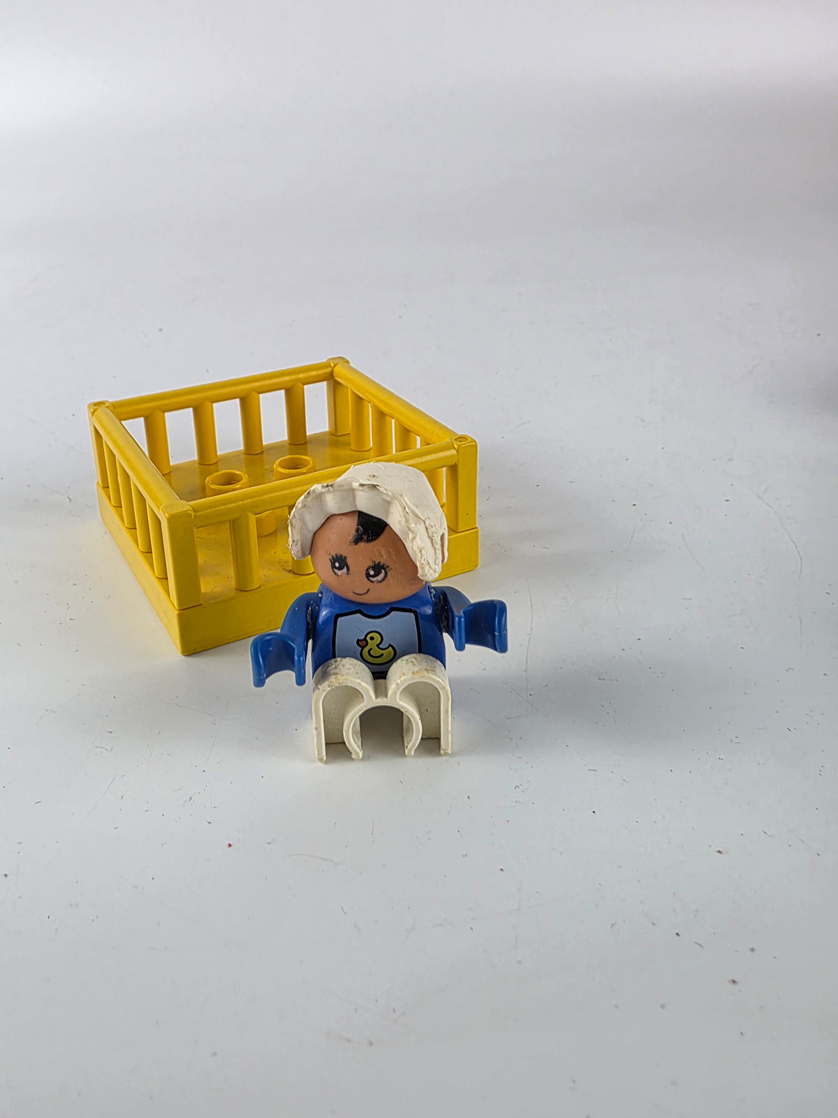 LEGO DUPLO baby figure inside a yellow playpen/crib